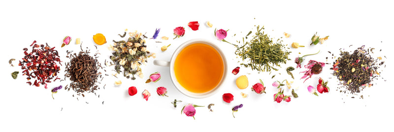 Horizontal layout with a white cup of tea in the center, with a narrow border around the cup a out to the sides of artfully arranged loose leaf teas and flower petals.